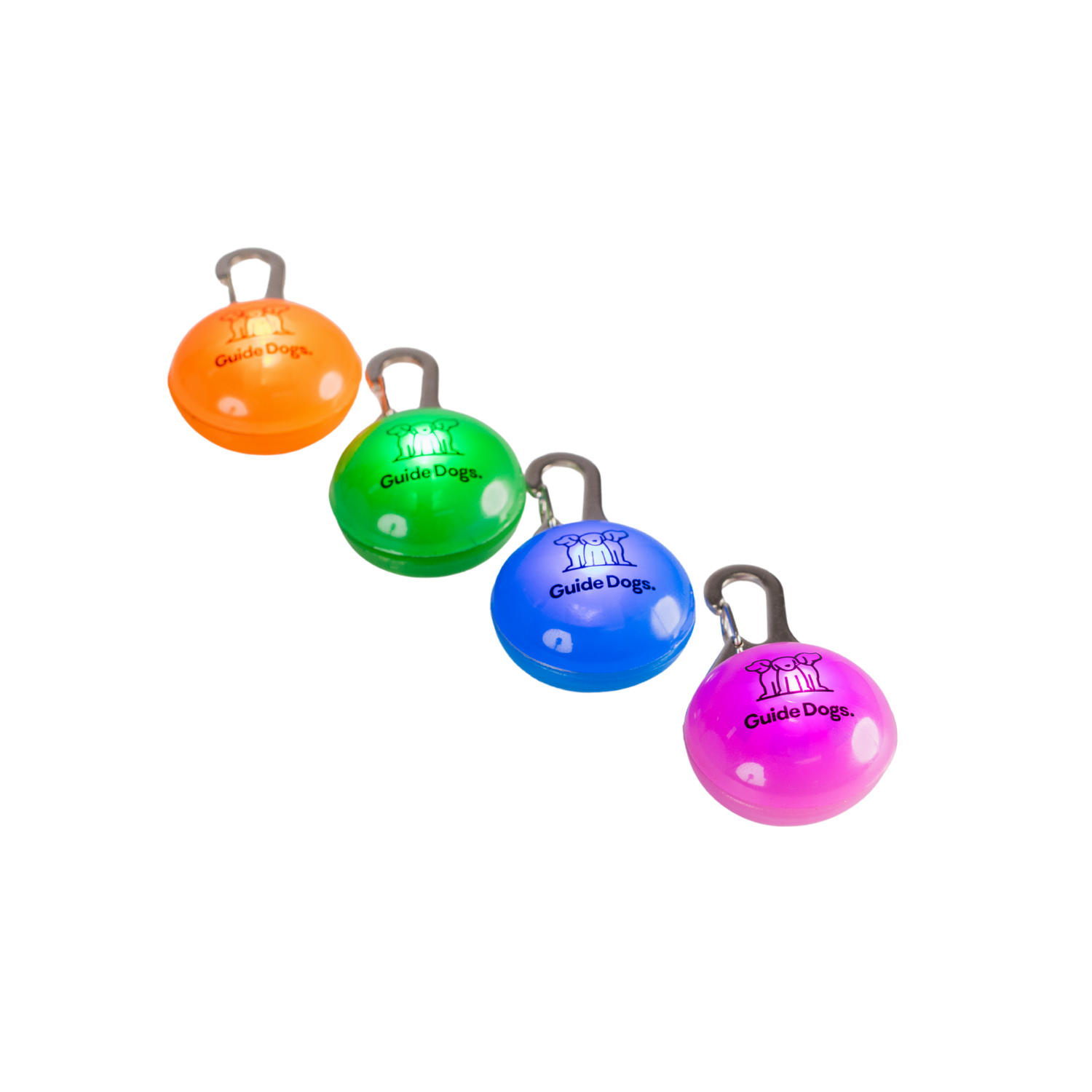 Four round LED keychain lights in orange, green, blue, and purple are arranged in a row. Each has a metal clip and the “Guide Dogs” logo on the front.