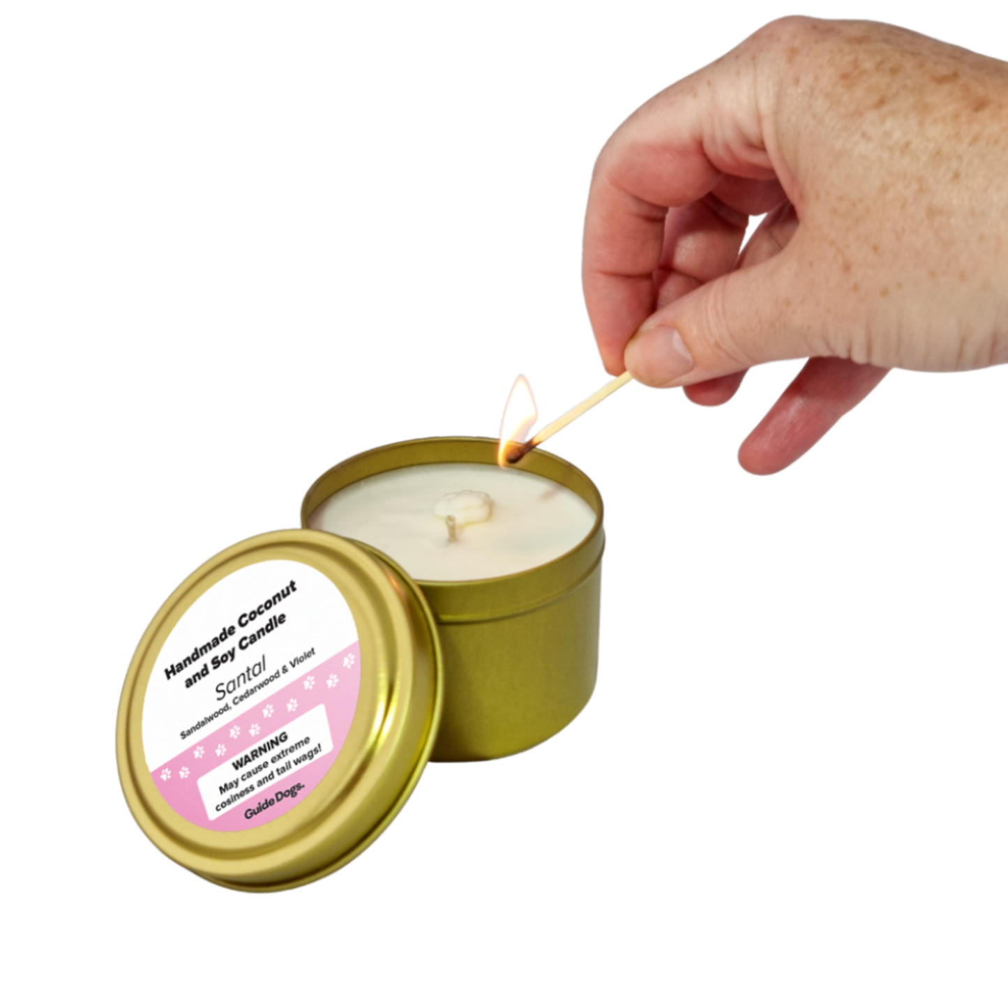 Image of a hand lights the Candle Tin - Gold, an Australian handcrafted candle; its lid rests nearby.