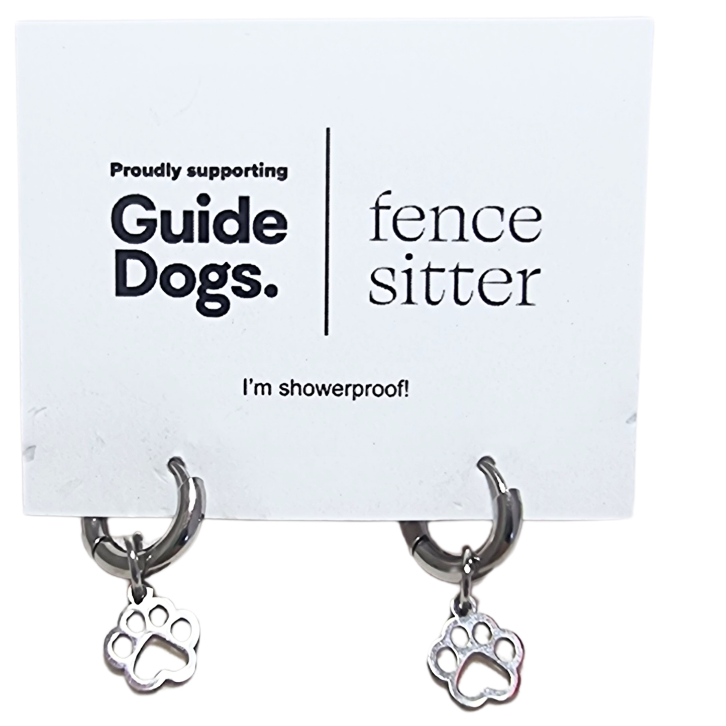 Image of a pair of earrings with paw charm on a card supporting Guide Dogs.