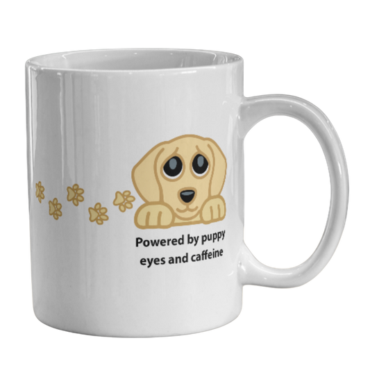 Image of a white ceramic coffee mug featuring a cartoon puppy graphic and the text 'Powered by puppy eyes and caffeine' on a plain white background.