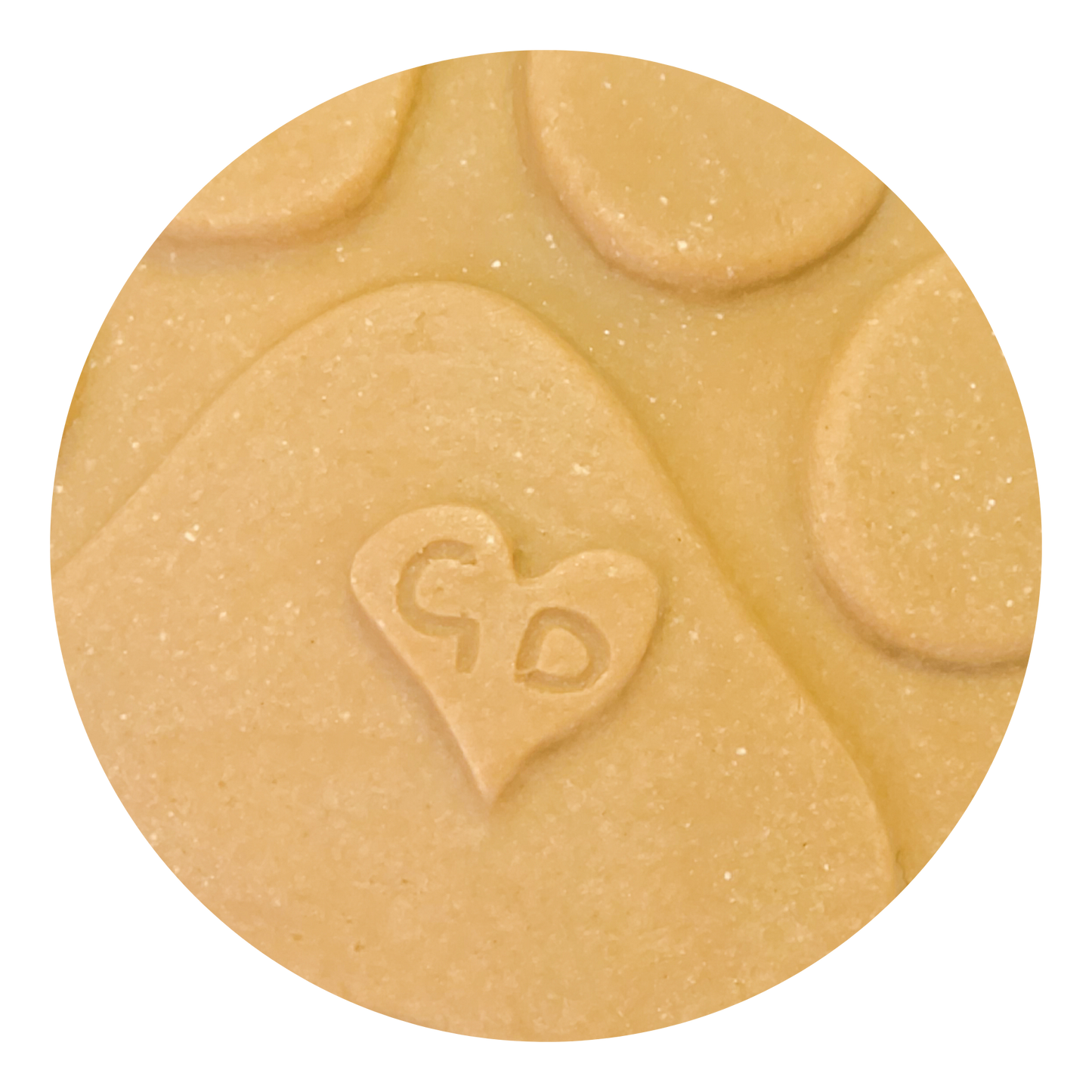 Image of A close-up of a handcrafted Christmas Ornament shaped like a paw print, with a heart and “GD” engraved on it.