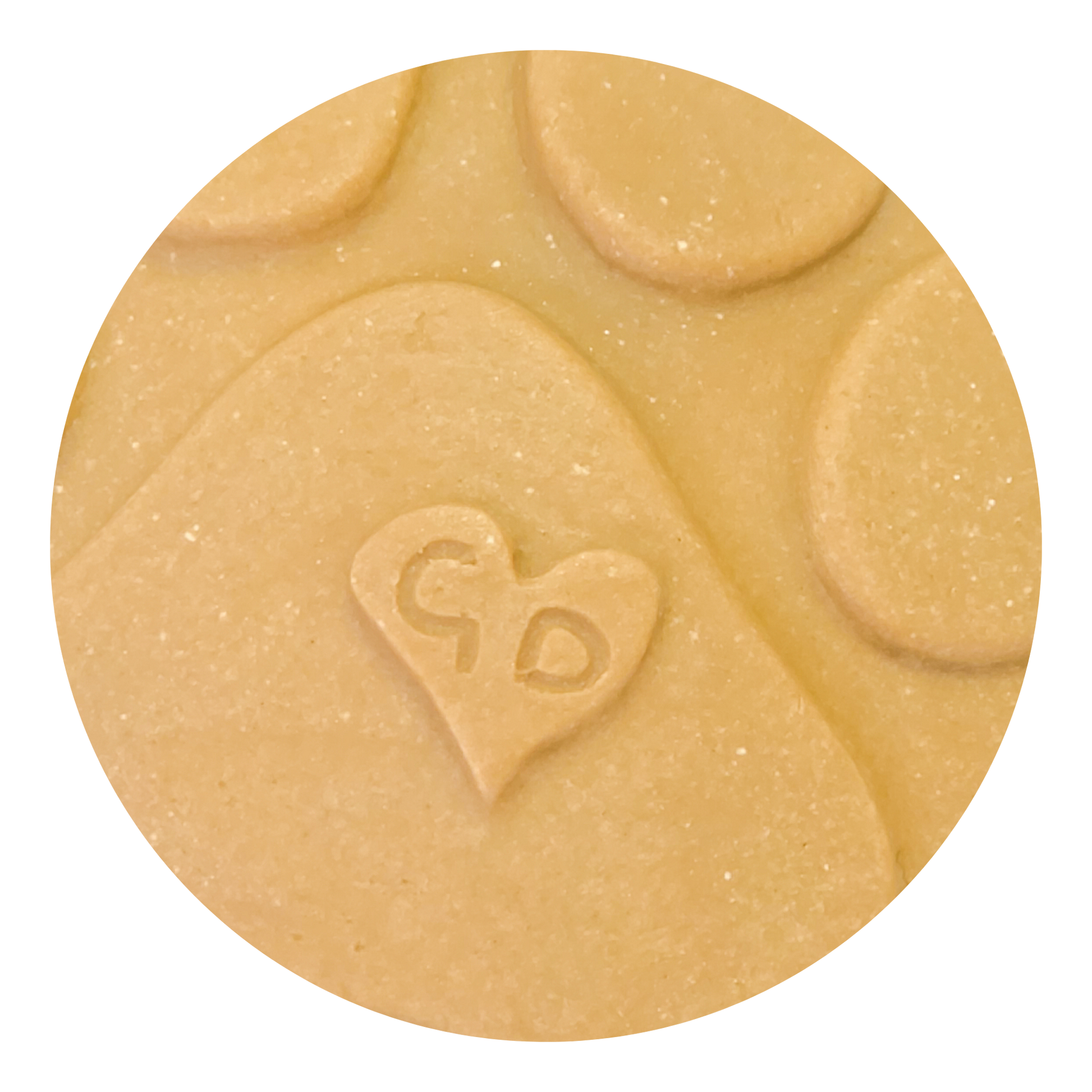 Image of A close-up of a handcrafted Christmas Ornament shaped like a paw print, with a heart and “GD” engraved on it.