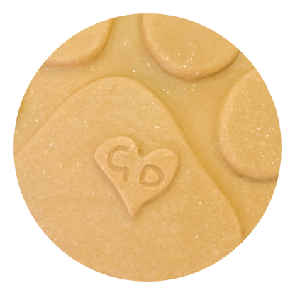 Image of A close-up of a handcrafted Christmas Ornament shaped like a paw print, with a heart and “GD” engraved on it.