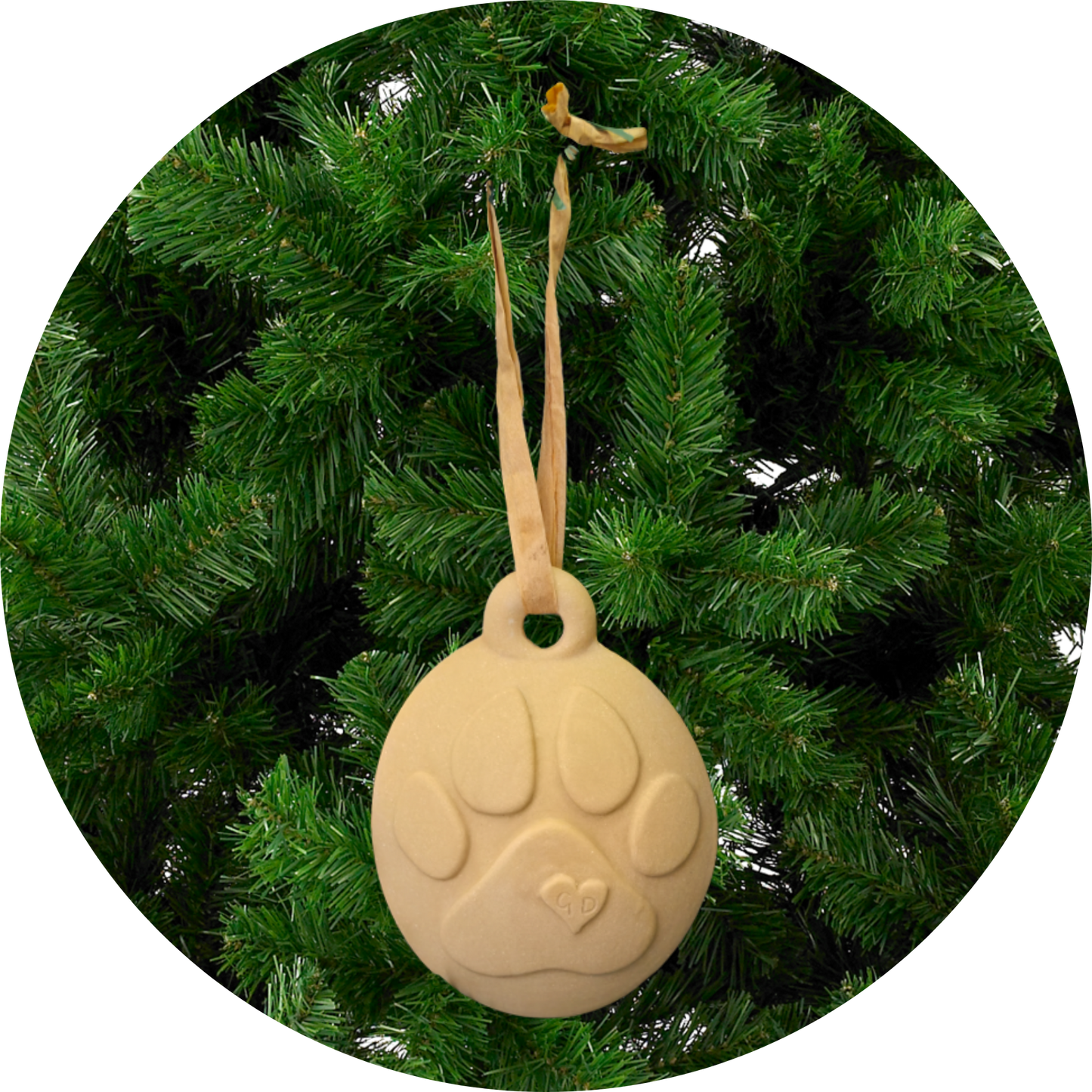 Image of Christmas Ornaments with paw prints hang from ribbons on a green artificial Christmas tree.