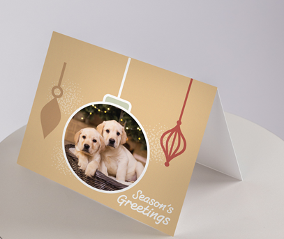 Image of a yellow card with yellow labs in an ornament frame with Seasons Greetings on the front.