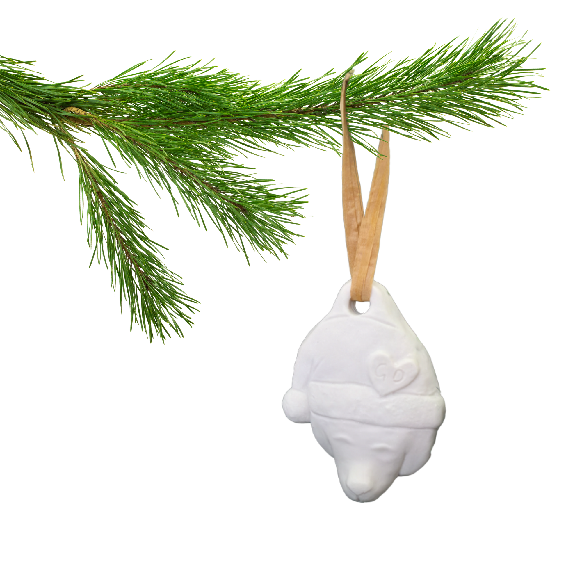 Image of A pine branch displays a Christmas Ornament: a white bear head with Santa hat and brown ribbon.