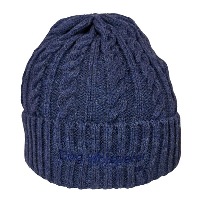 Image of a  navy blue cable-knit beanie hat with a ribbed cuff and the embroidered text 'Dog Whisperer' on the front, shown against a plain white background.