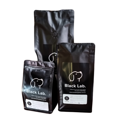 Image of three black Soho Coffee bags with a dog face outline, on a white background.