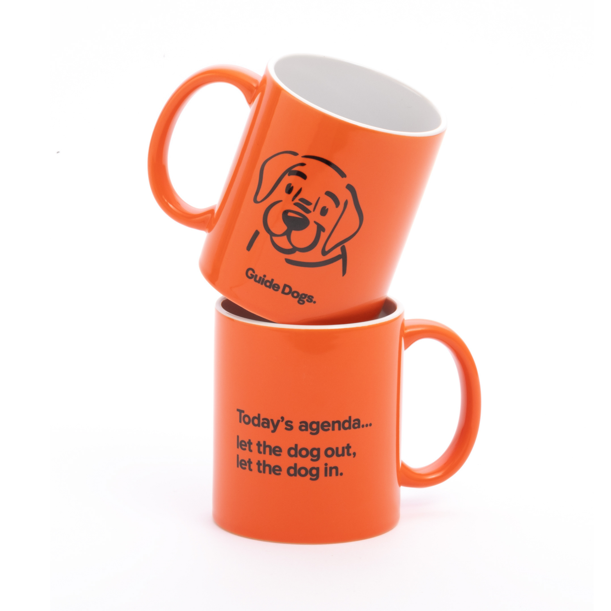 Image of two stacked orange mugs. The top mug shows a dogs face with the words Guide Dogs. The bottom mug reads Todays agenda... let the dog out, let the dog in.