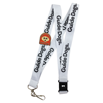 Image of an Enamel Pin featuring a cartoon dog's face pinned to a white lanyard with black Guide Dogs logo.
