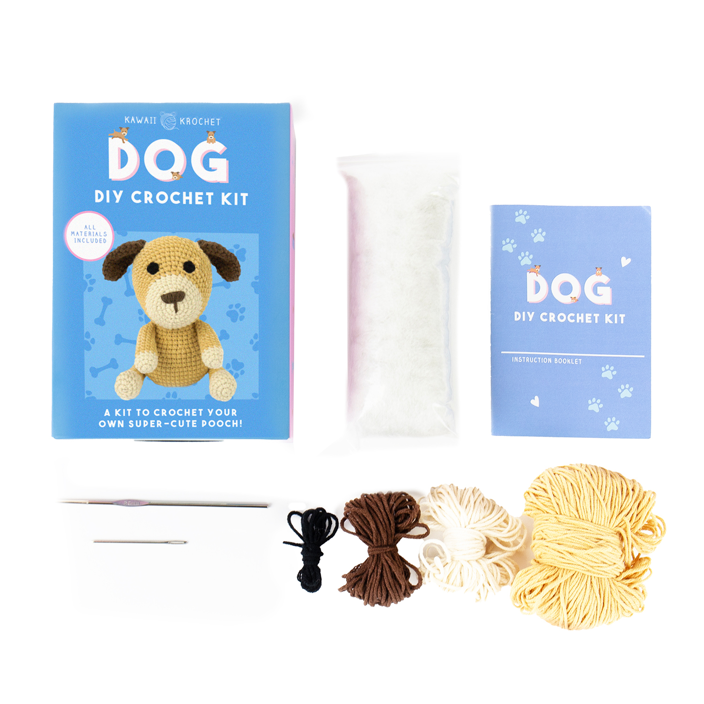 Image of a top-down view of the Crochet Kit for beginners, showing a blue box with a crochet dog image, stuffing, instruction booklet, two crochet needles, black and brown thread, and three yarn skeins in brown, cream, and yellow.