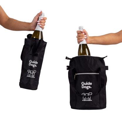 Image of two hands holding Guide Dogs cooler bags with bottles inside. On the left is a vertical single bottle bag; on the right, a Wine Cooler Bag  – with a zip, both shown against a white background.