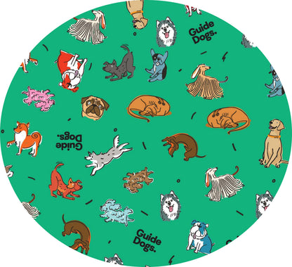 Image of circle of the green bandana featuring cartoon dogs, "Guide Dogs" text, and bone pattern.