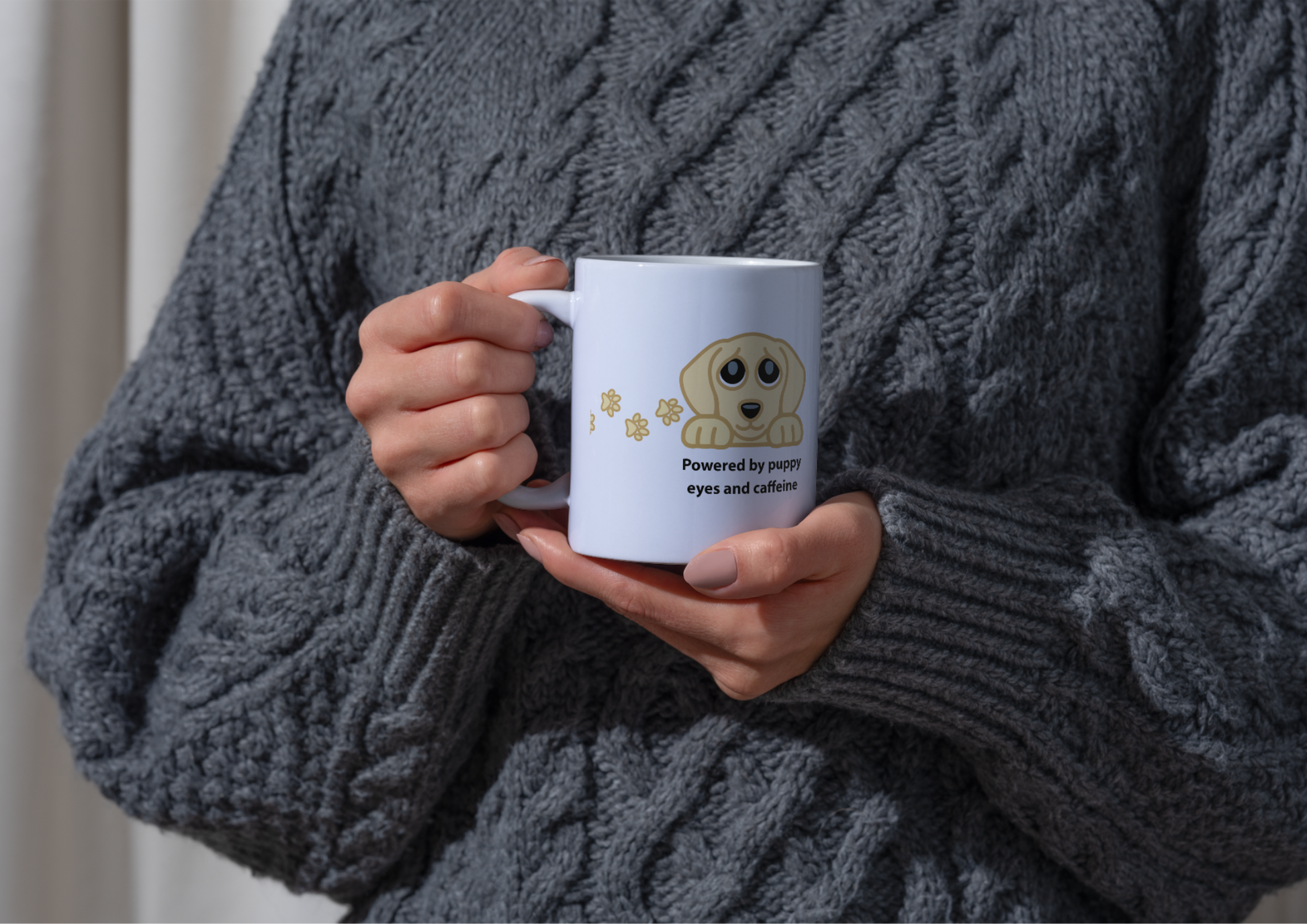 Image of a person wearing a chunky gray cable-knit sweater holds a white ceramic mug with a cartoon golden retriever and the text 'Powered by pure eyes and affection'.