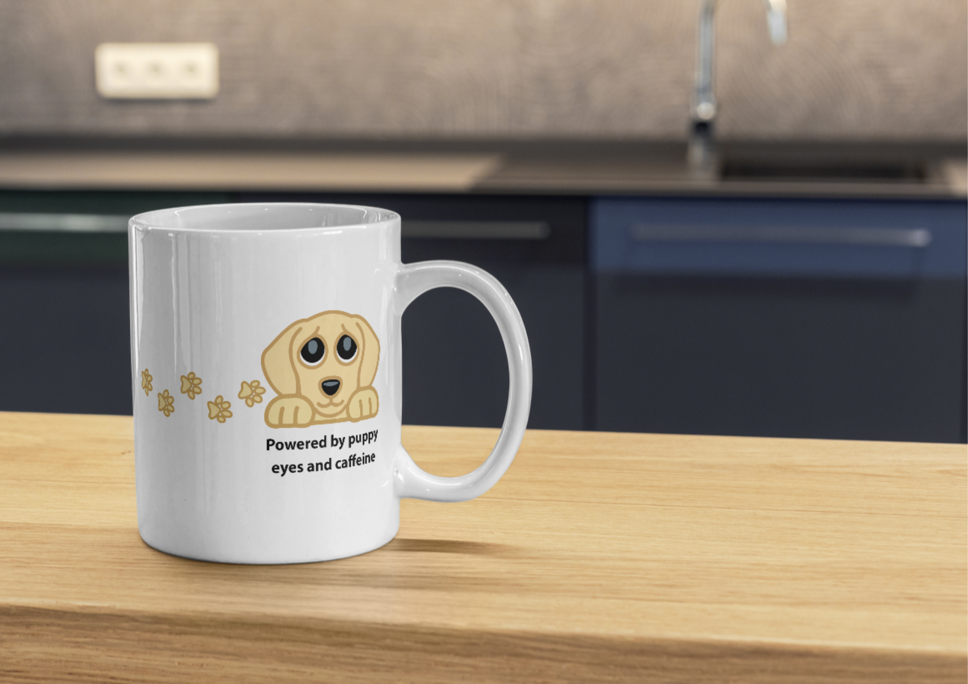Image of a white ceramic coffee mug with a cartoon puppy graphic and the text 'Powered by puppy eyes and caffeine' sitting on a wooden countertop in a kitchen setting.