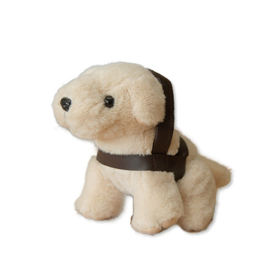Image of the cream Mini Plush Dog, featuring a brown harness, sits on a white background.