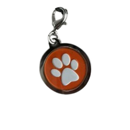 Image of a round metal charm with a white paw print on an orange background.