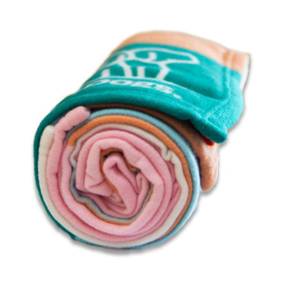 Image of rolled up multicolored blanket with teal, pink, peach & white layers on a white background.