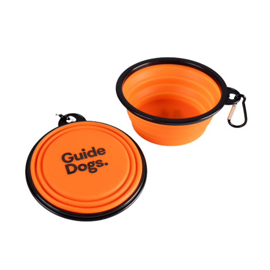 Image of Two Dog Bowl - Collapsible Orange, black rims, clip; Guide Dogs text; one open, one folded.